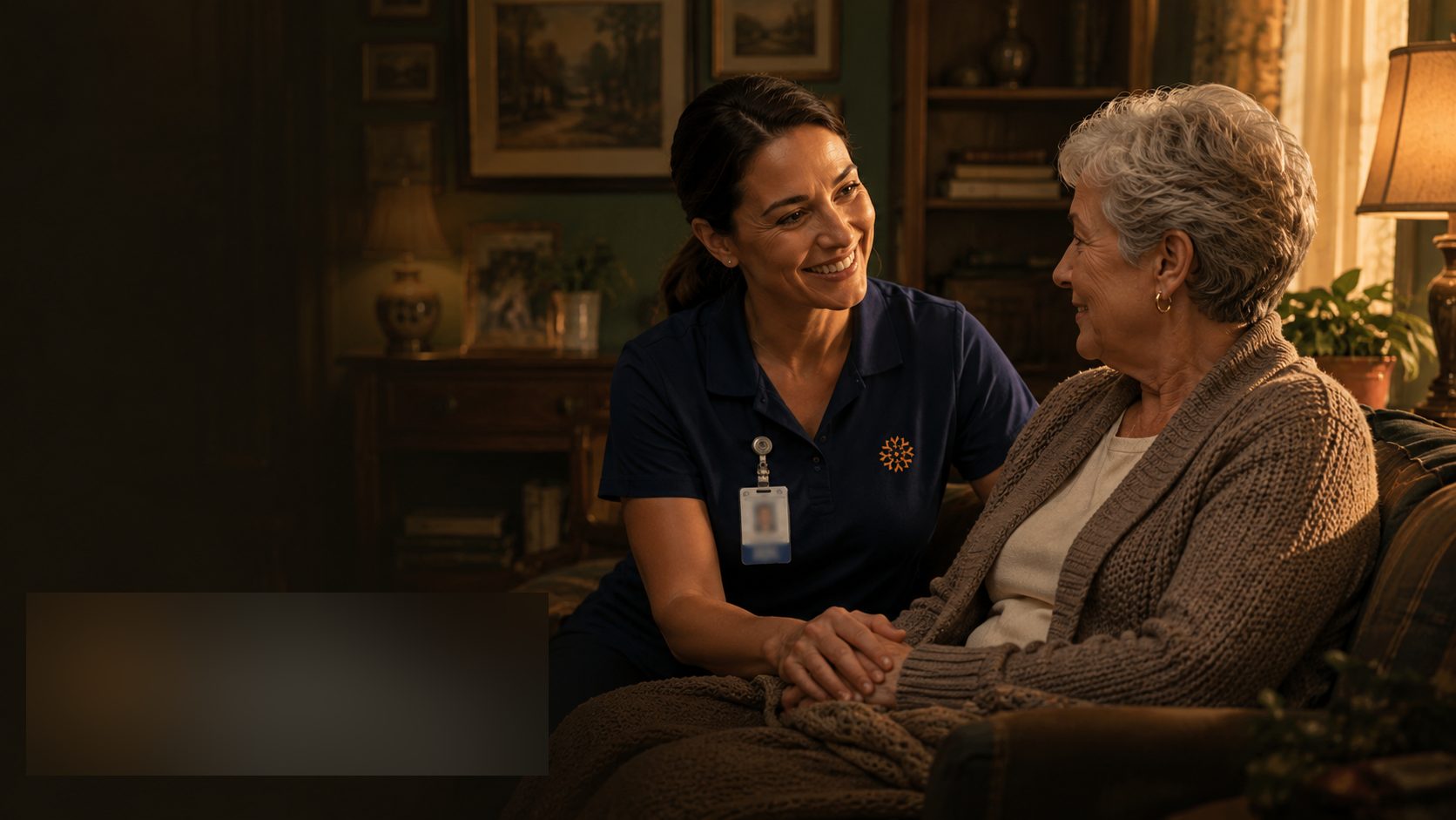 An A First Name Basis caregiver sitting with a client at home.